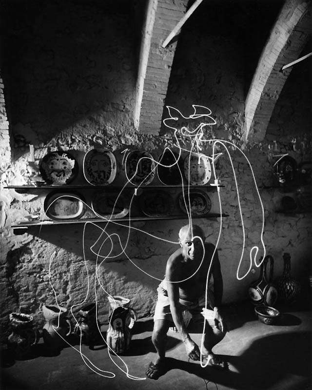 Фотография Пабло Пикассо, который фонариком рисует кентавра в воздухе, 1949 год